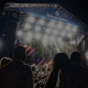 Escenario iluminado con gente disfrutando del concierto